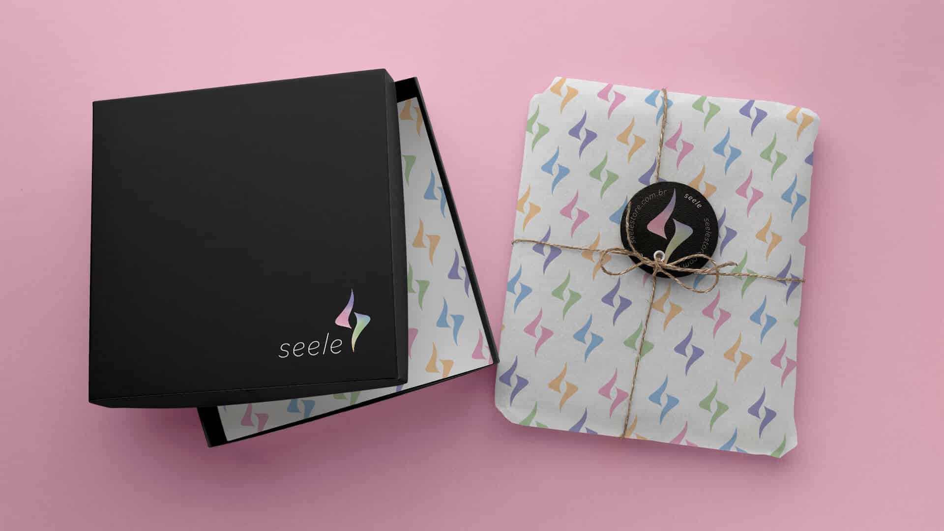 caixa preta com logo seele e embrulho com papel de seda com simbolos seele coloridos